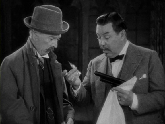 Charlie Chan (Warner Oland) examining the airgun with which an attempt on his life was undertaken in 'Charlie Chan in London' (Forde 1934)