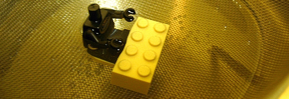 A LEGO minifig being freed from its magnet base